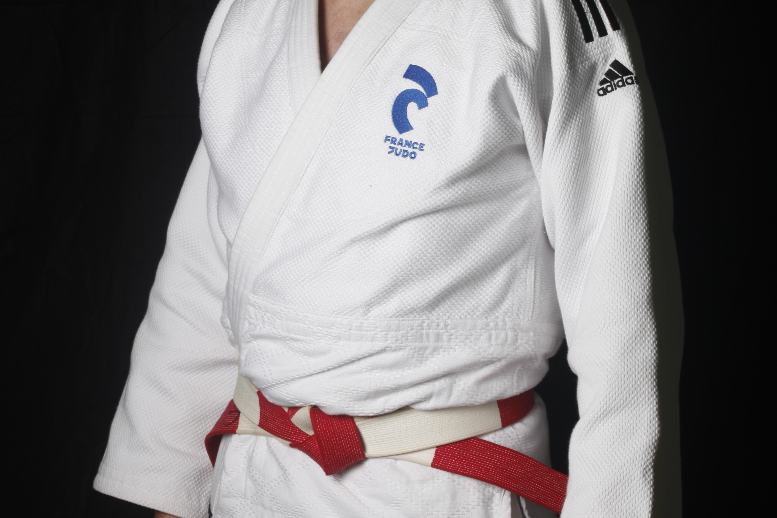 Judogi blanc, logo France Judo bleu, Adidas avec bandes noires, ceinture de haut-gradé blanche et rouge